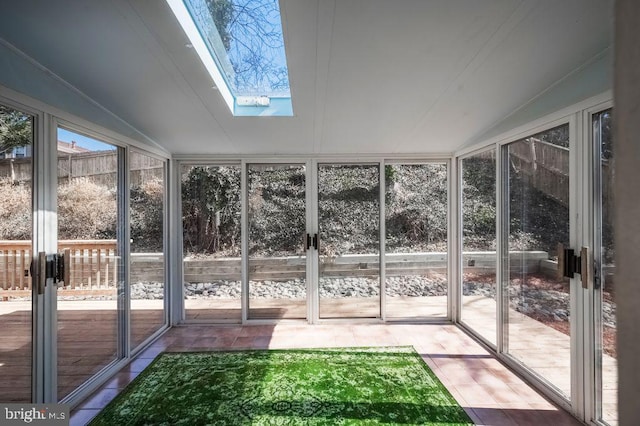 unfurnished sunroom with vaulted ceiling with skylight