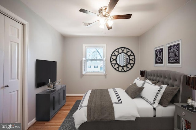 bedroom with a ceiling fan, light wood-style flooring, and baseboards