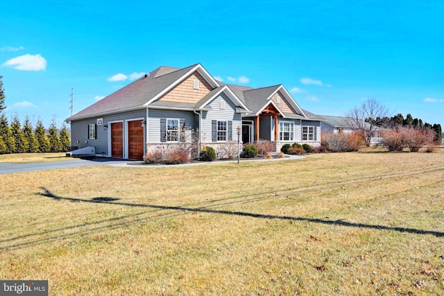 view of front facade with aphalt driveway, an attached garage, and a front lawn