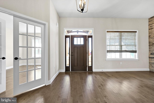 foyer featuring dark wood finished floors, baseboards, and a wealth of natural light