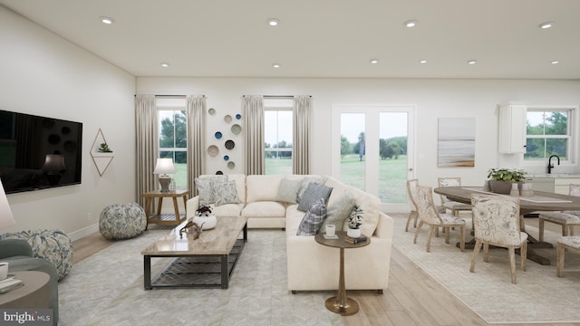 living room with light wood-style floors, baseboards, and recessed lighting