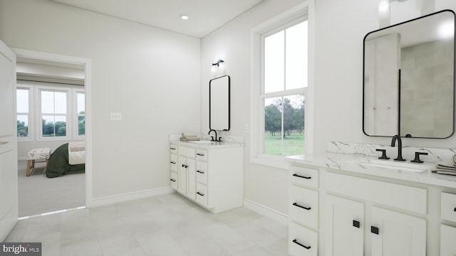 full bathroom featuring a healthy amount of sunlight, ensuite bath, and a sink