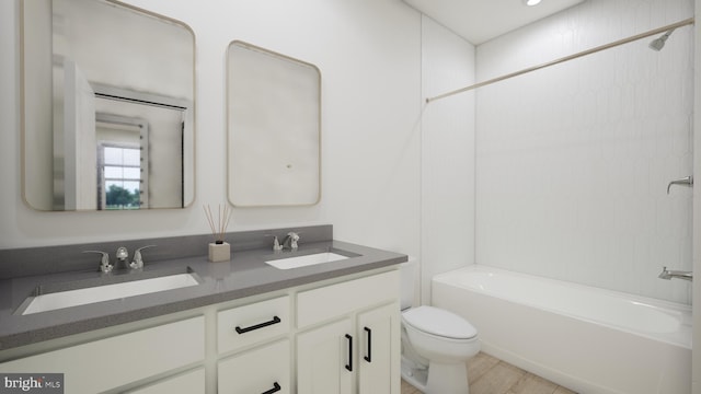 bathroom with double vanity, shower / tub combination, toilet, and a sink