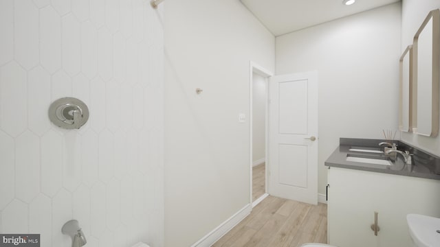 bathroom featuring vanity, baseboards, and wood finished floors