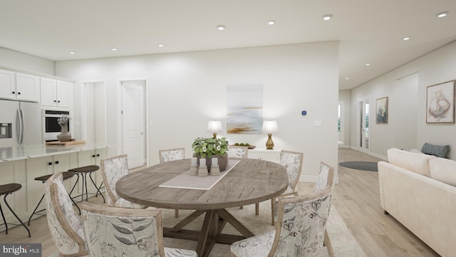 dining space featuring baseboards, light wood finished floors, and recessed lighting