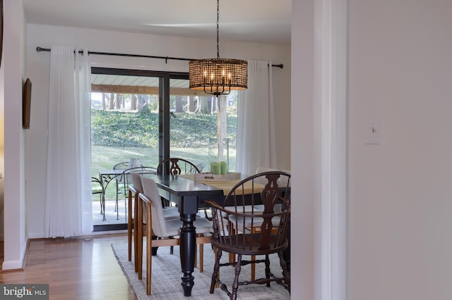 dining room featuring a chandelier, a wealth of natural light, and wood finished floors