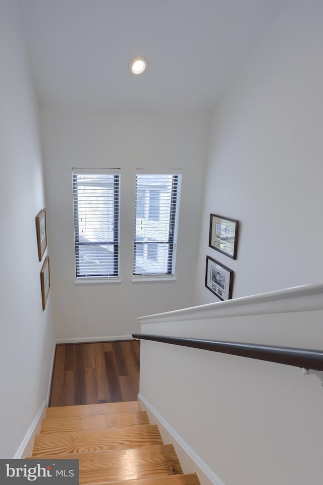 stairs with baseboards, wood finished floors, and recessed lighting