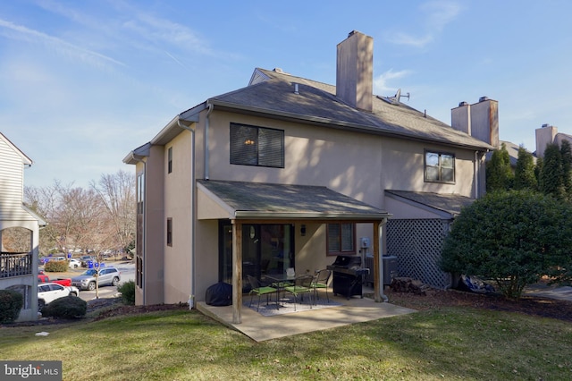 back of house with central air condition unit, a lawn, a patio area, and stucco siding