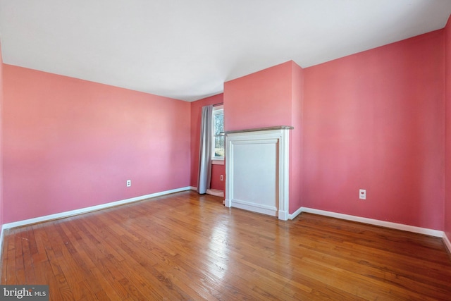 unfurnished living room with baseboards and hardwood / wood-style floors