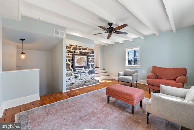 living room featuring visible vents, baseboards, stairs, hardwood / wood-style floors, and beamed ceiling