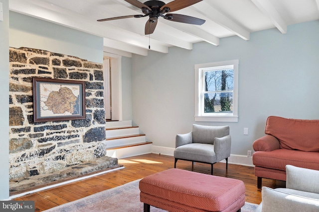 living room with stairway, hardwood / wood-style floors, a ceiling fan, beamed ceiling, and baseboards