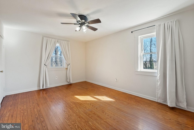 unfurnished bedroom with wood-type flooring, a ceiling fan, and baseboards