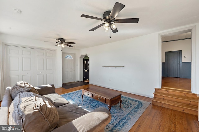 living room with arched walkways, ceiling fan, and wood finished floors