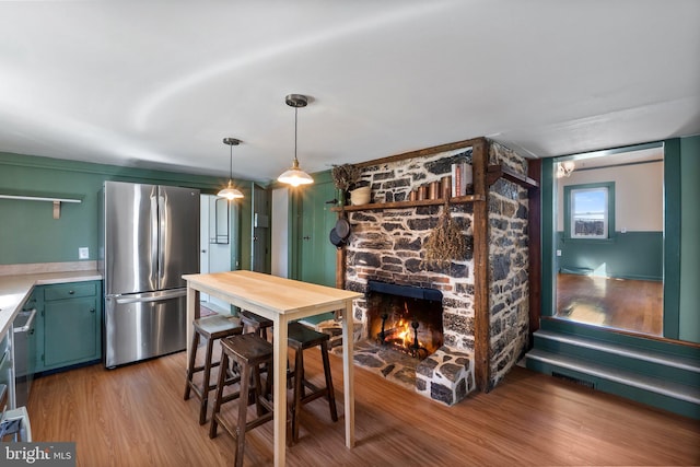 dining area with a stone fireplace and light wood-style floors