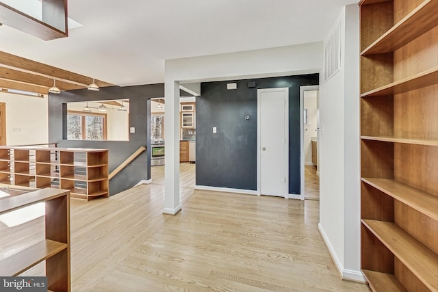 entrance foyer with wood finished floors, visible vents, and baseboards