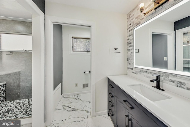 full bath featuring visible vents, baseboards, decorative backsplash, marble finish floor, and vanity