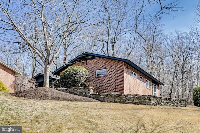 view of side of property with a yard and brick siding