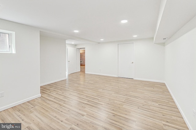 basement featuring baseboards, light wood-type flooring, and recessed lighting