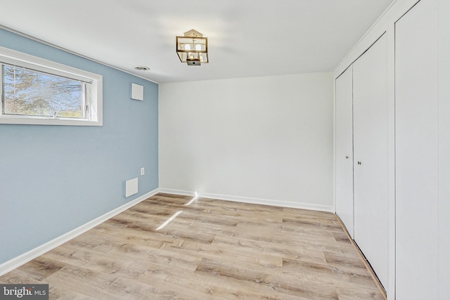 unfurnished dining area featuring light wood-type flooring and baseboards