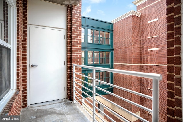 entrance to property with a balcony and brick siding