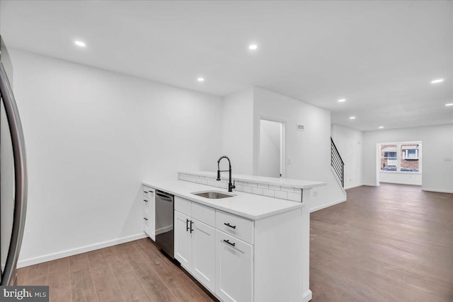 kitchen with a peninsula, white cabinets, light countertops, and open floor plan