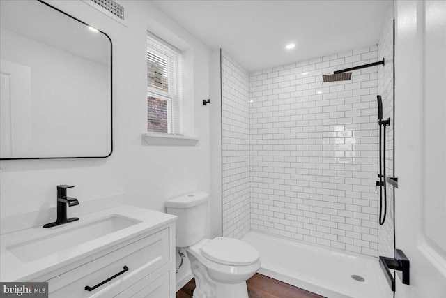 full bathroom featuring a stall shower, vanity, toilet, and wood finished floors