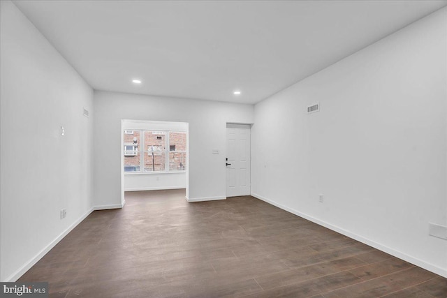 unfurnished room with dark wood-type flooring, recessed lighting, visible vents, and baseboards