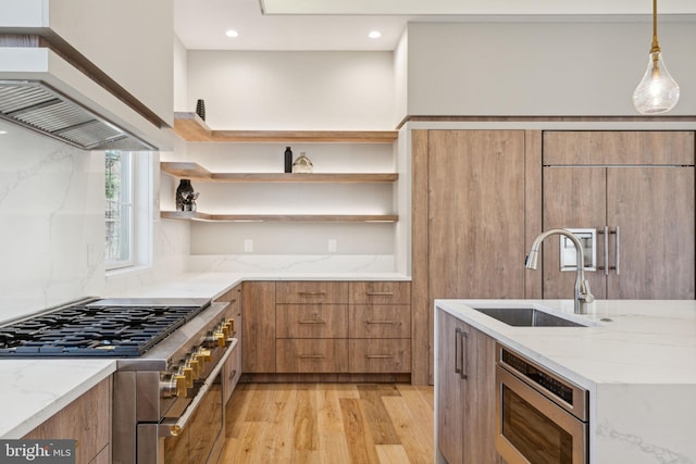 kitchen with light stone counters, stainless steel appliances, a sink, open shelves, and modern cabinets