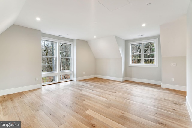 bonus room with light wood-type flooring, baseboards, and lofted ceiling