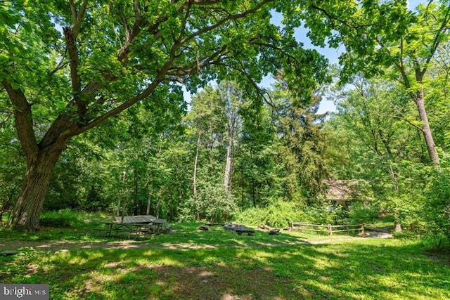 view of yard featuring fence and a wooded view