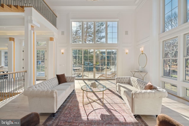 living room with a towering ceiling and a decorative wall