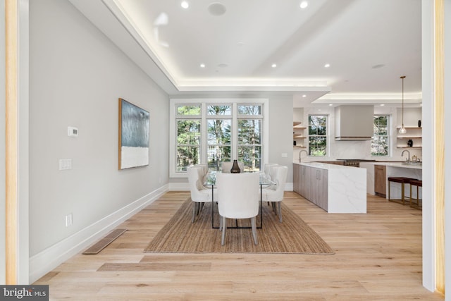 dining area with visible vents, a raised ceiling, baseboards, light wood-style flooring, and recessed lighting