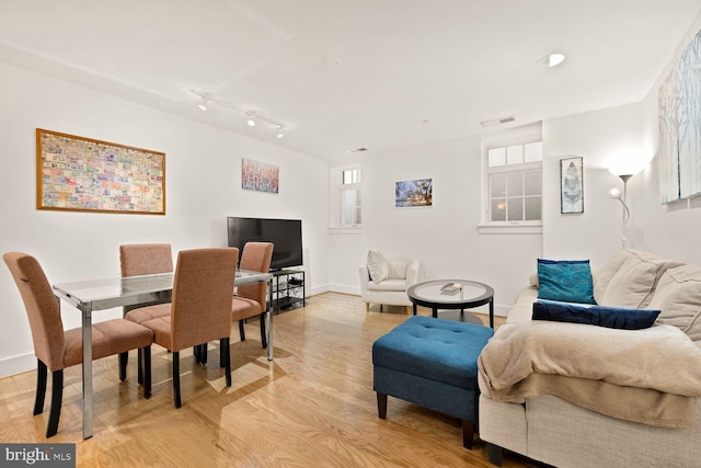 dining area with visible vents, light wood-style flooring, and baseboards