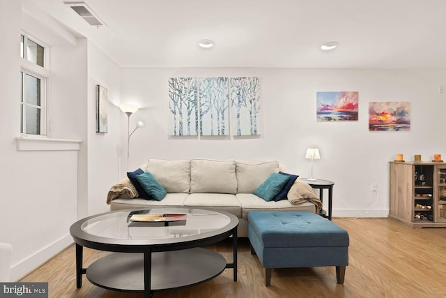 living room featuring light wood-style floors, baseboards, visible vents, and recessed lighting