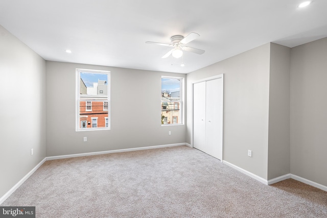 unfurnished bedroom featuring ceiling fan, a closet, baseboards, and carpet flooring