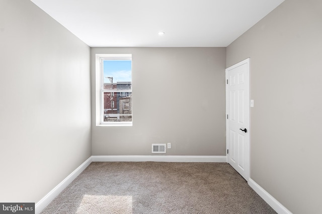 spare room with baseboards, visible vents, and carpet flooring