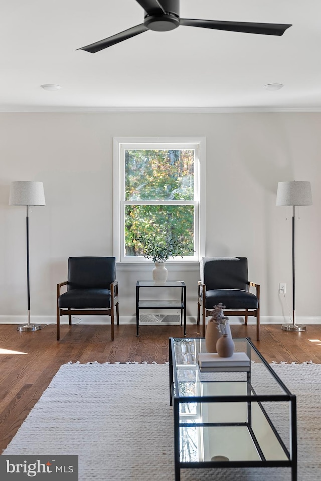 sitting room featuring dark wood-type flooring, baseboards, and a ceiling fan