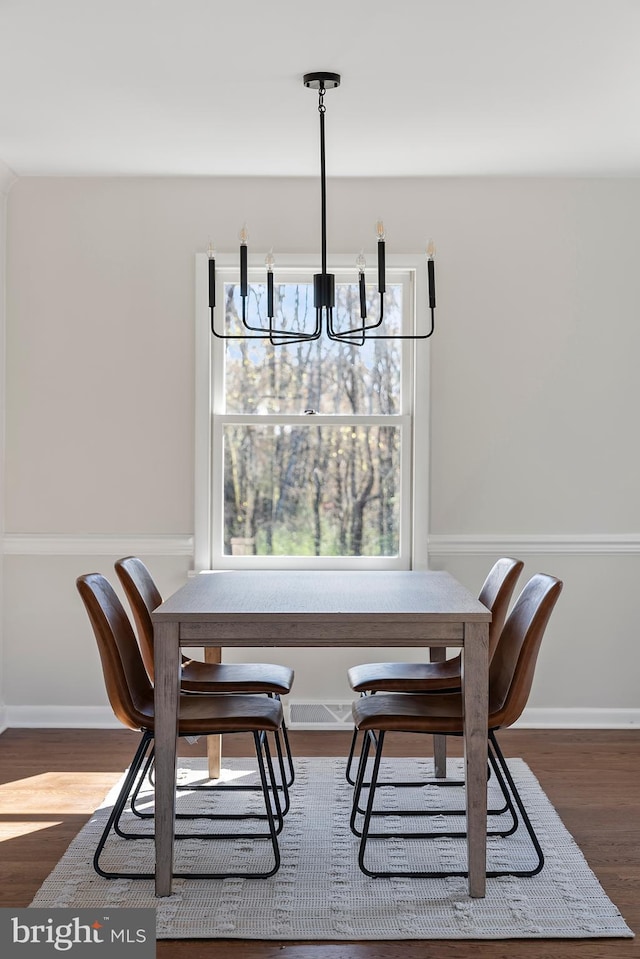 dining space featuring baseboards, a chandelier, and dark wood-type flooring