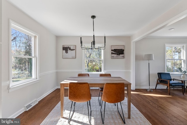 dining room with baseboards, visible vents, and wood finished floors