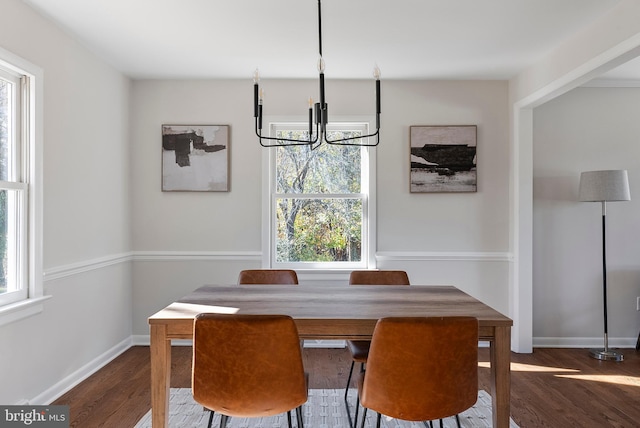 dining room with a notable chandelier, dark wood-style flooring, and baseboards