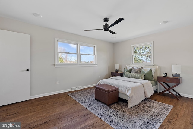 bedroom with visible vents, multiple windows, baseboards, and dark wood finished floors