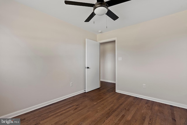 spare room with a ceiling fan, baseboards, and dark wood-style flooring