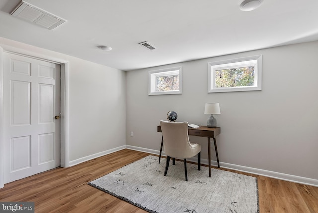 office space featuring visible vents, baseboards, and wood finished floors