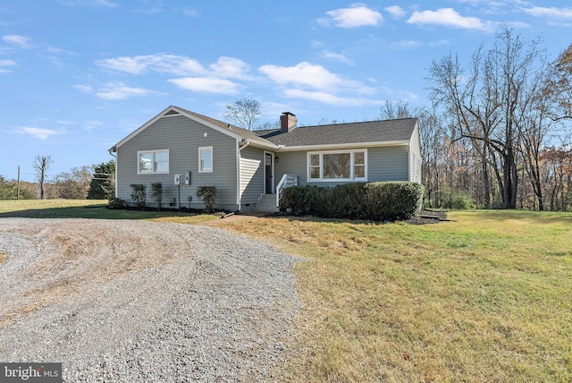 view of front of house with a front yard, roof with shingles, crawl space, a chimney, and gravel driveway