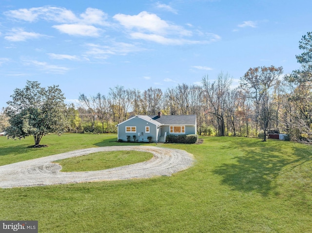 view of front of home featuring a front yard, driveway, and a chimney