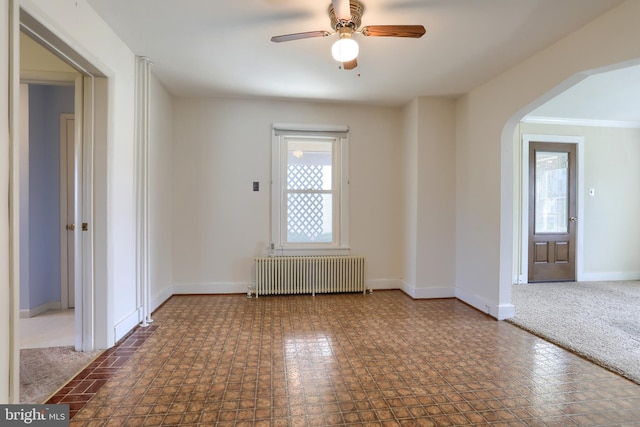 659 E Maple St, Annville, PA 17003 - empty room featuring baseboards, arched walkways, radiator, and ceiling fan