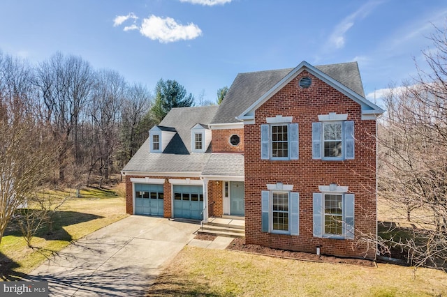 view of front of home with a shingled roof, a front yard, brick siding, and driveway