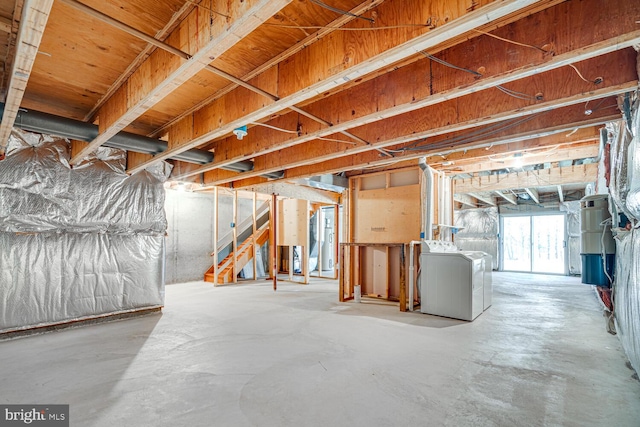 below grade area with water heater, stairs, and washer and dryer