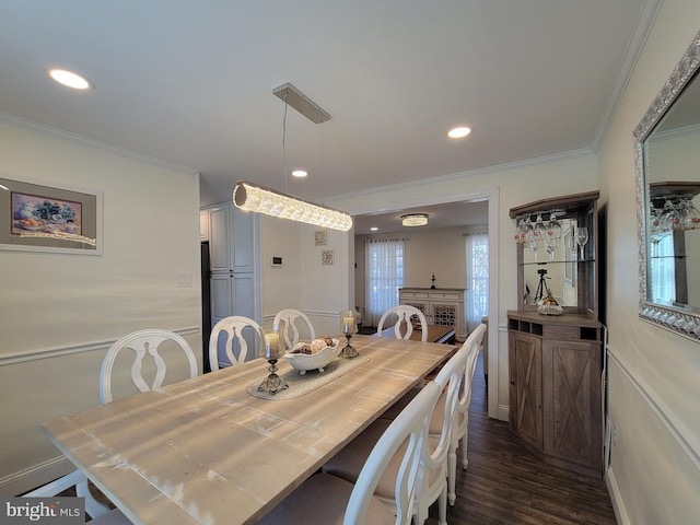 dining space with dark wood finished floors, crown molding, and recessed lighting