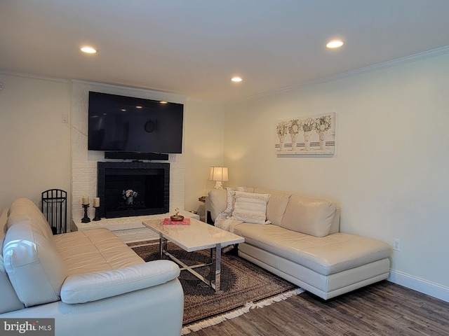 living room featuring baseboards, a brick fireplace, wood finished floors, and recessed lighting